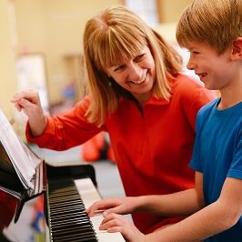 teacher and child on a piano